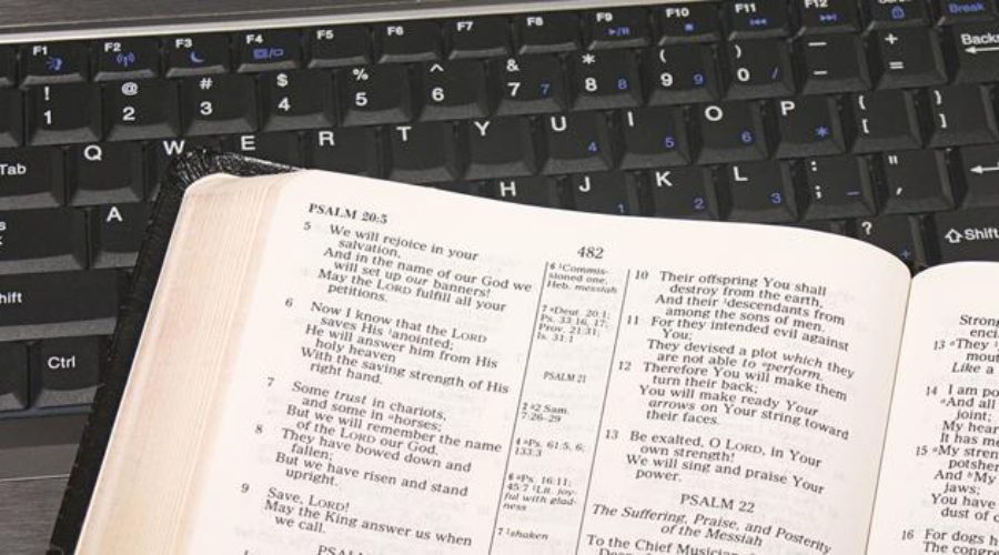 A Bible next to a keyboard