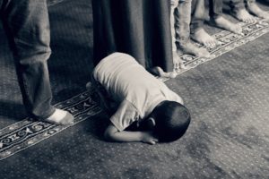 Picture of a child praying, demonstrating the effects of faith and fatherhood