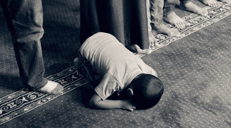 Picture of a child praying, demonstrating the effects of faith and fatherhood