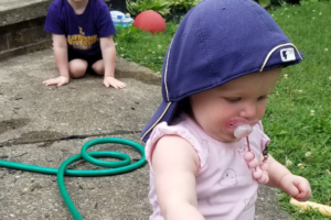 My kids playing in the yard with a garden hose