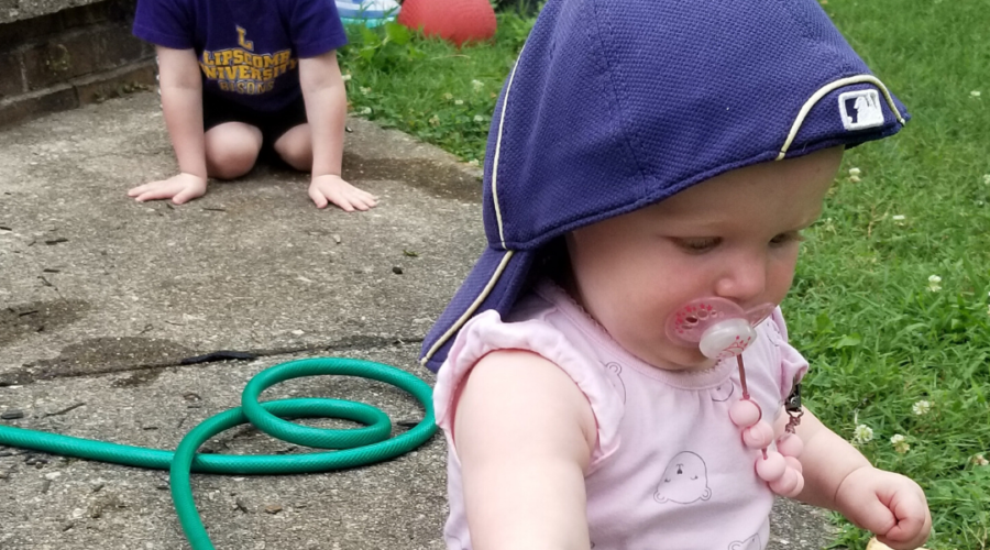 My kids playing in the yard with a garden hose