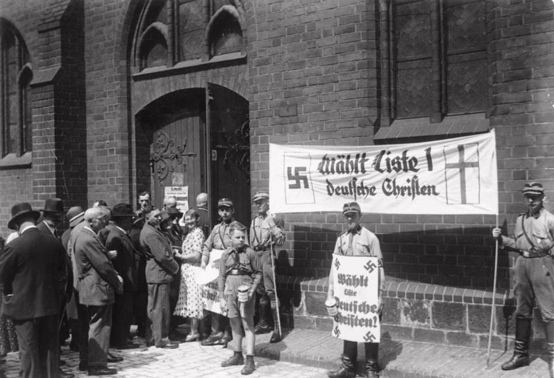 Stormtroopers holding German Christian propaganda during the Church Council elections on 23 July 1933, at St. Mary's Church, Berlin